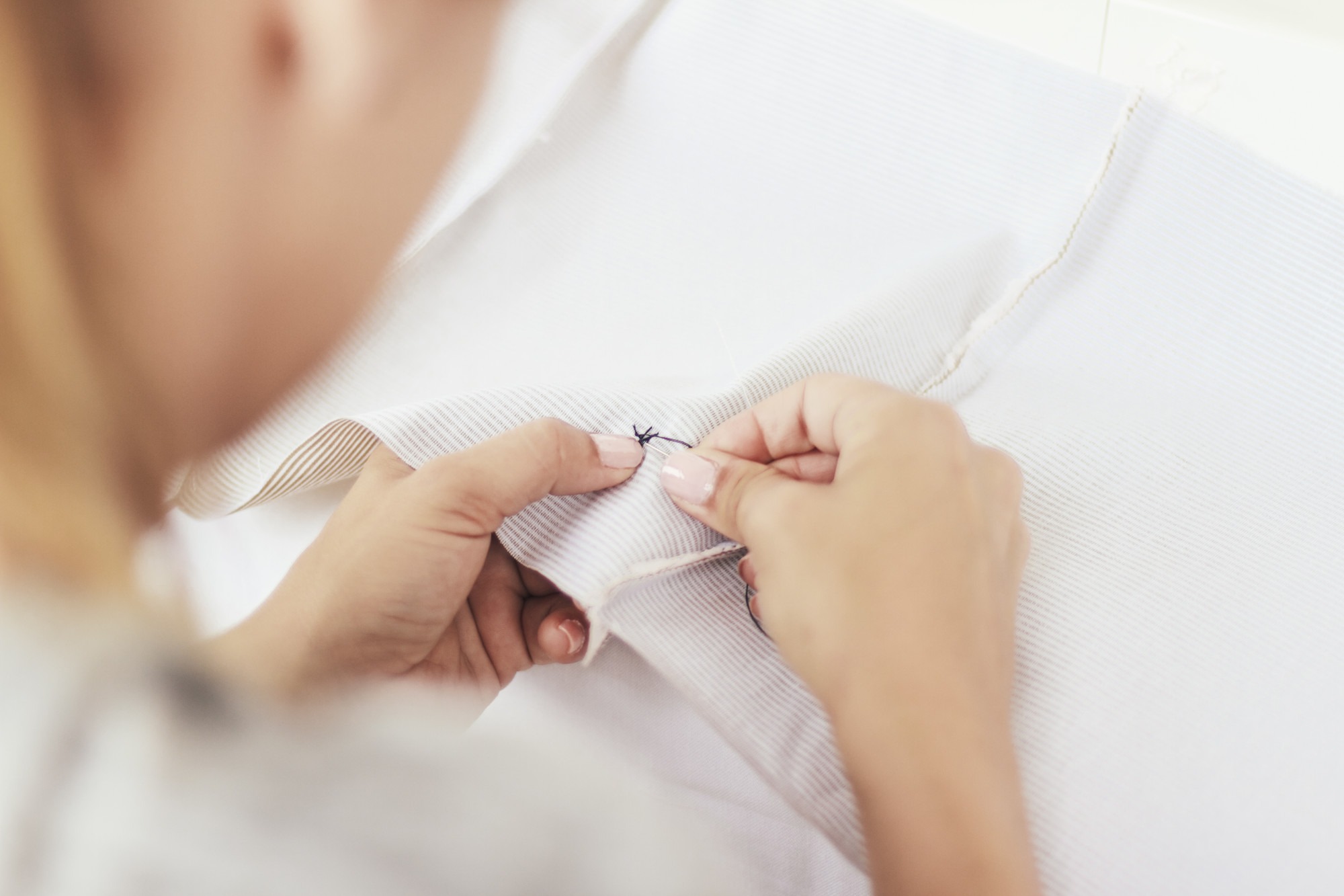Portret asystentki pracującej nad detalem haftu